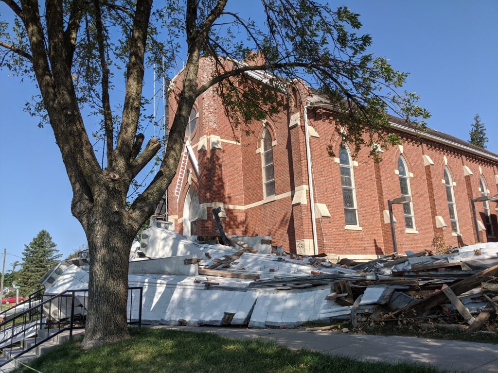 Rubble surrounding a church that has visible storm damage.
